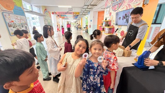 Students proudly displaying the Racial Harmony Day badges they created.